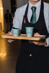 Cafering barista bringing a coffee drink to a guest at an event