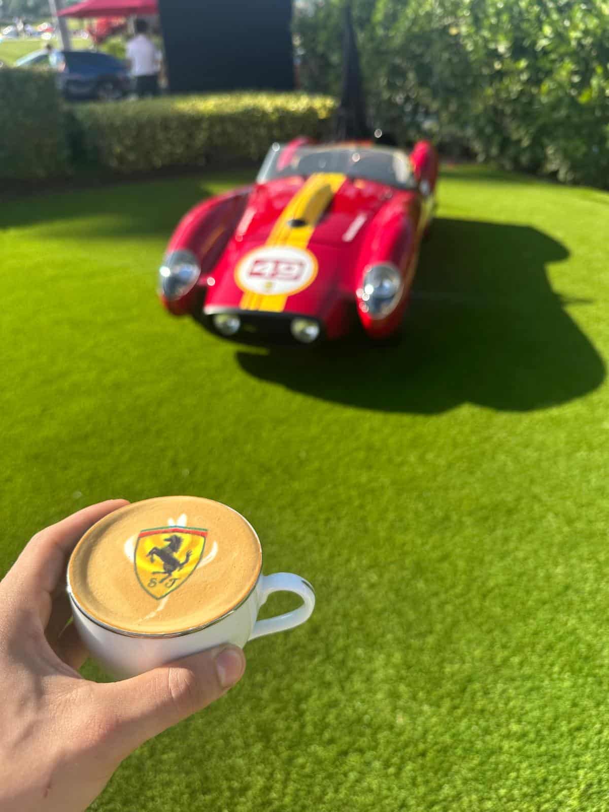 Ferrari logo printed on coffee with a red Ferrari in the background