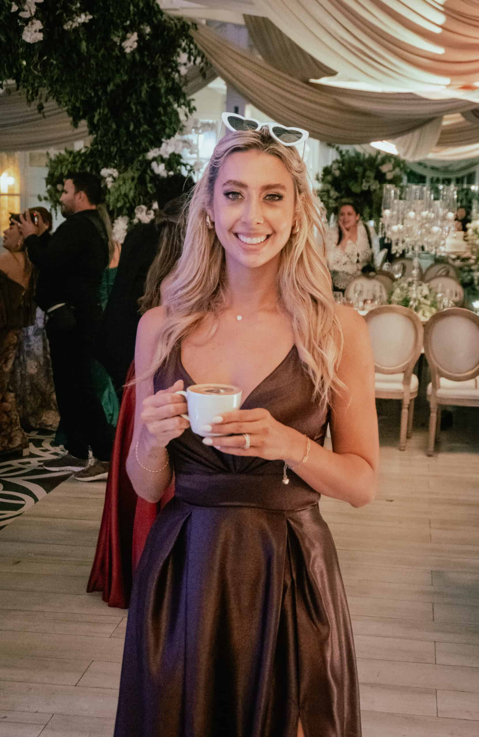 Happy guest holding a coffee at a wedding