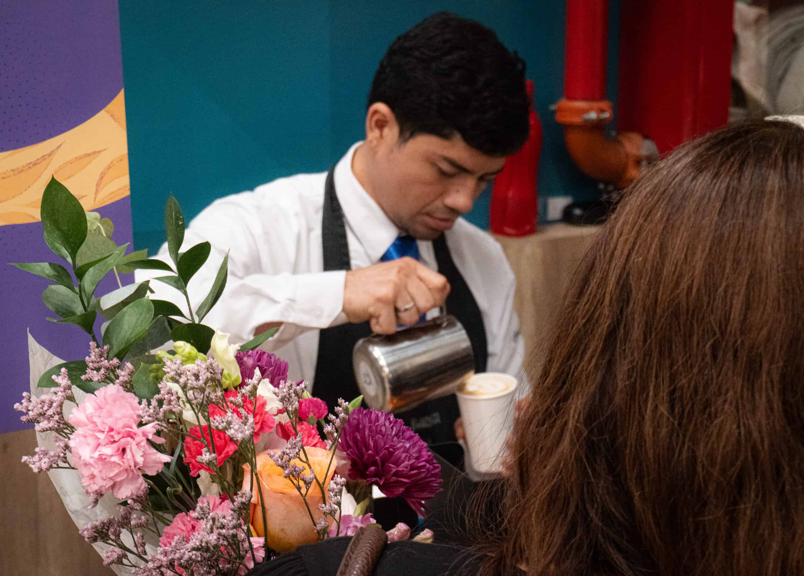 Barista pouring latte art at a wedding